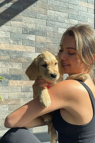 Woman happily cuddling with a puppy at the Tricon Retreat Pop up.